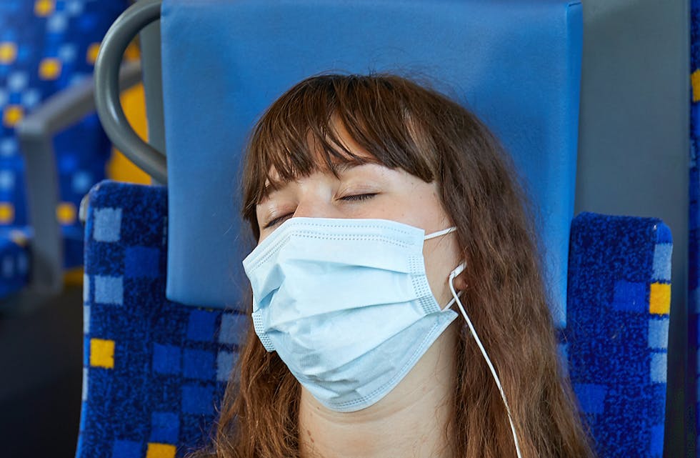 Young woman on a train wearing masks