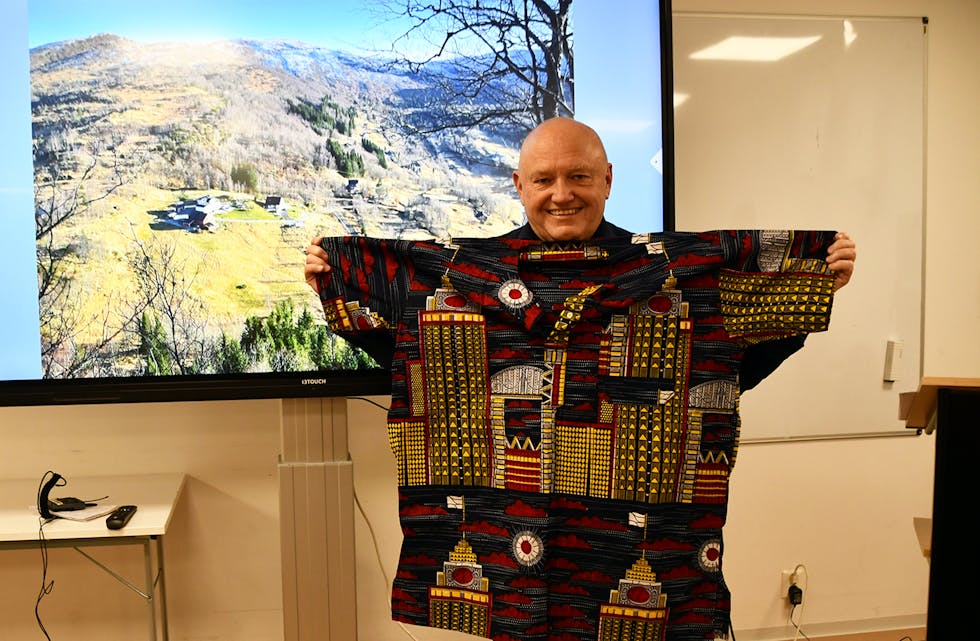 NESTEKJÆRLEIK: Denne flotte skjorta fekk Svein Høysæter då han var i Mali. Sjølv om dei han heldt kurs for nesten ikkje hadde pengar til mat, var det så viktig for dei at han skulle føla seg velkomen og inkludert hos dei. I bakgrunnen er gardstunet på Høysæter.