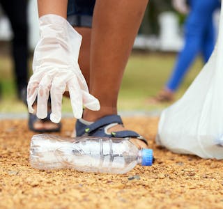 Volunteer hands, bottle and woman cleaning garbage, pollution or trash waste for environment support. Community recycling, NGO charity and eco friendly people help with nature park plastic clean up