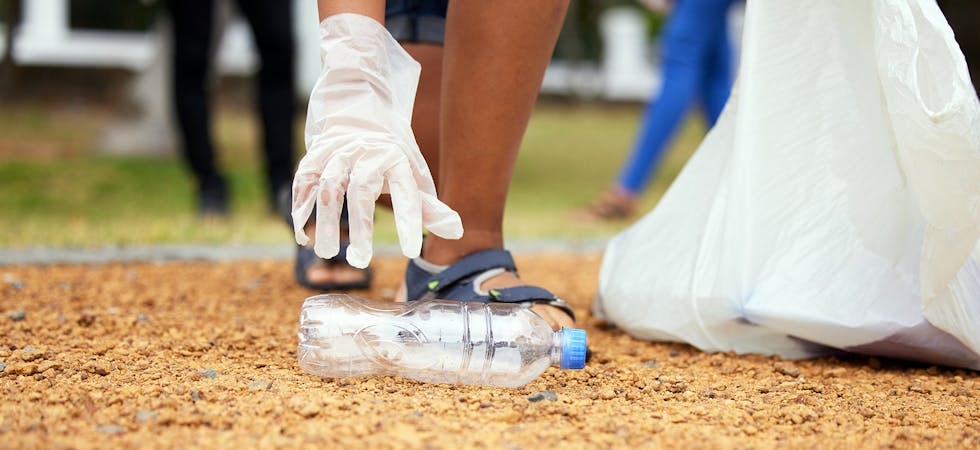 Volunteer hands, bottle and woman cleaning garbage, pollution or trash waste for environment support. Community recycling, NGO charity and eco friendly people help with nature park plastic clean up