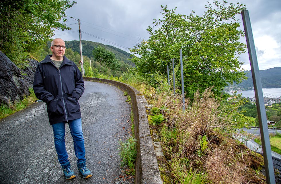 KREV TILTAK: David Vogel er bekymra for born som går langs denne vegen i Bjørkhaugen. Nedanfor for muren stuper terrenget, og det manglar gjerde. No har Bjørkhaugen Vel bede kommunen om å ordna opp.