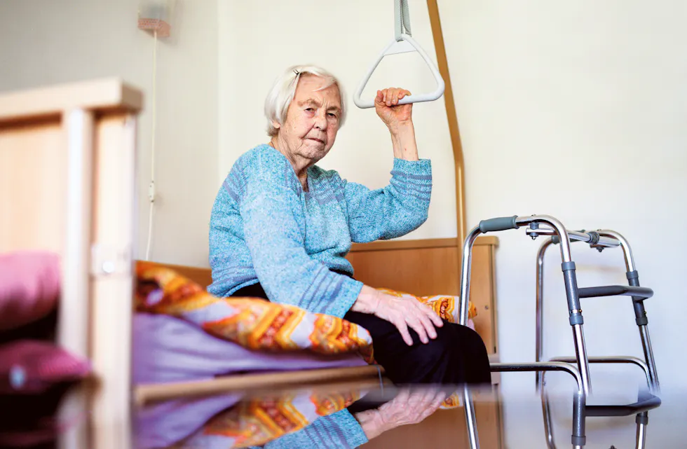 Elderly 96 years old woman sitting on medical bed in hospic.